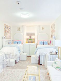 two beds in a room with white furniture and pictures on the wall above them,