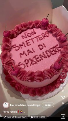 a pink cake with writing on it sitting in a box