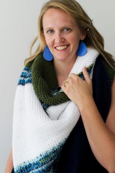 a woman wearing blue earrings and a scarf