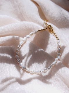 "This beaded bracelet features a collection of tiny white freshwater pearls to capture the enticement of Hawaii's white sand beaches. Wear this gold pearl bracelet alone or stracked for a classically elegant allure. ✦ DETAILS ✦ ✧ Name: Maile (MIE-leh) - vine. ✧ Adjustable Length from: 6\"-7.5\" Inches. ✧ White 3-4mm Freshwater Pearls. ✧ 14kt Gold Filled Components, Extender, and Clasp. ✧ All Ke Aloha Jewelry pieces come packaged thoughtfully, beautifully, and ready for gift giving. ✦ MORE GOLD B Pearl White Pearl Beaded Jubilee Bracelets, Pearl White Pearl Beaded Jubilee Bracelet, Pearl White Beaded Bracelet With Pearl Drop, Delicate White Bangle Bracelet, Adjustable Pearl White Bracelet With Pearl Chain, Adjustable Pearl White Bracelets With Pearl Chain, Handmade Dainty Pearl White Bracelets, Dainty Pearl Charm Beaded Bracelets, Dainty Beaded Pearl Bracelets With Charm