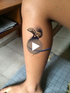 a person with a lizard tattoo on their leg