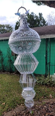 a large glass vase sitting on top of a grass covered field next to a building