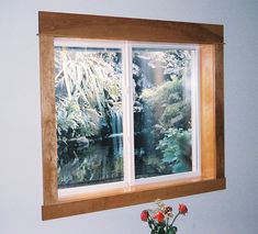 a vase filled with flowers sitting on top of a window sill next to a wall