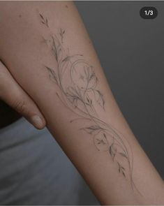 a woman's arm with flowers and vines on the left side of her body