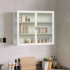 a kitchen with white cabinets and silver counter tops