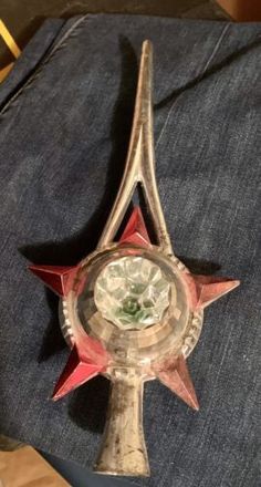 a red and white clock sitting on top of a pair of jeans