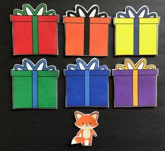 four different colored boxes with bows on them and one has a fox in the middle