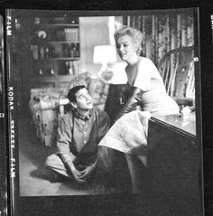 an old black and white photo of a woman sitting next to a man