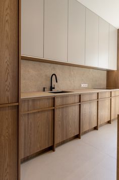 an empty kitchen with wooden cabinets and black faucet