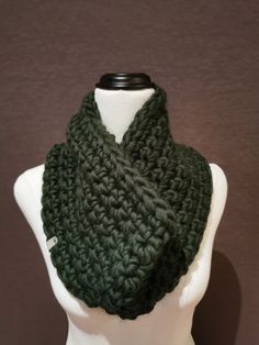 a green knitted scarf on top of a white mannequin head