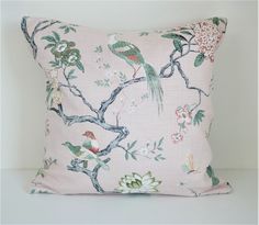 a pink pillow with birds and flowers on it