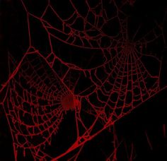 a spider web is glowing red in the dark