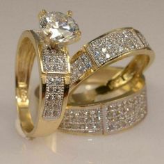 two gold wedding rings with white diamonds on each one and an engagement ring in the middle