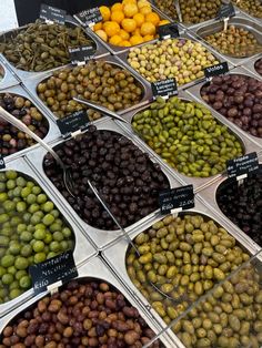 an assortment of olives and oranges on display