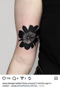 a woman's arm with a black and white flower tattoo on the left forearm