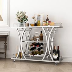 a bar cart with wine bottles and glasses on it