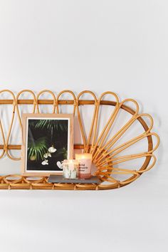 a bamboo shelf with candles and pictures on it