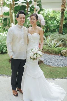 a bride and groom pose for a photo in front of flamingos at their wedding