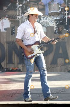 a man in cowboy hat playing guitar on stage