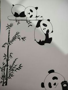 two pandas are hanging upside down on a bamboo tree and one is sitting in the air