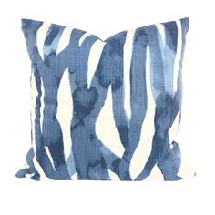 a blue and white pillow on a white background