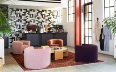 a living room filled with lots of furniture next to a tall plant in a vase