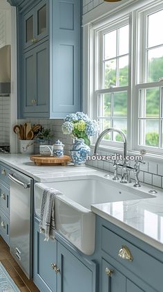 a kitchen with blue cabinets, white counter tops and an island sink in the middle