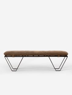 a bench that is sitting on some kind of metal frame with a brown seat cushion