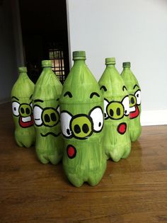 four green angry birds soda bottles sitting on top of a wooden floor