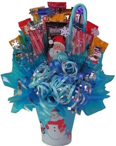 a bucket filled with candy and candies on top of a white table next to a blue ribbon