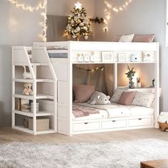 a white bunk bed with lights on the ceiling and some stuffed animals in front of it