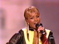 a woman with blonde hair is singing into a microphone