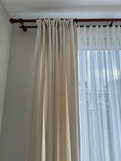 the curtains are hanging in front of the window with white drapes on it's sides