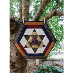 a patchwork quilt hanging from a tree