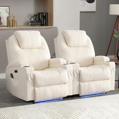 two white recliners sitting next to each other on a rug in a living room