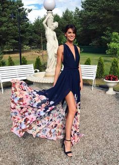 a woman standing in front of a statue wearing a dress