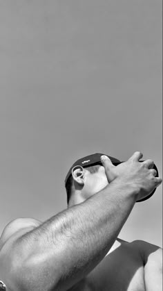 a man holding a frisbee in his right hand and looking up at the sky