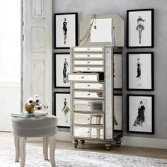 a room with pictures on the wall and a white stool in front of it,