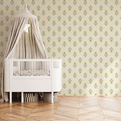 a white crib in front of a wallpapered room with yellow and green flowers