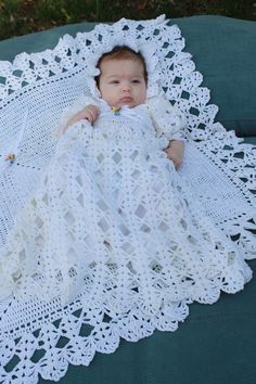 a baby wrapped in a white crochet blanket