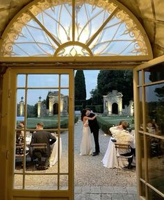 a bride and groom standing in front of an open door to their wedding reception room