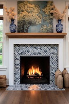 a fireplace in a living room with blue and white vases