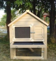 a large white chicken coop sitting in the grass