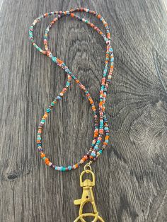 "I call this color combination of beads \"Turquoise Harvest\". This beautiful lanyard is made with hand selected glass seed beads. It is very lightweight and comfortable to wear. We do custom designs also! Lanyards can be used to hold work or school ID badges, eyeglasses or sunglasses, keys, flash drives, life alert sensors, or whatever else you wish! They make wonderful gifts for teachers, hospital workers, and corporate employees. Available in 2 sizes: 34\" or 37\". Picture shown on model (5'7 Fall Teacher Lanyard, Colorful Beads Lariat Necklace For Beach, Bohemian Beaded Necklace With Lobster Clasp, Glass Bead Keychain, Multicolor Lariat Beaded Necklaces For Beach, Turquoise Lariat Beaded Necklace With Colorful Beads, Multicolor Lariat Beaded Necklace For Beach, Turquoise Lariat Beaded Necklace, Multicolor Bohemian Beaded Necklace