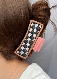 a woman wearing a hair clip with black and white checkered fabric in the back