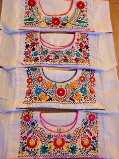 four different types of embroidered cloths laid out on the floor