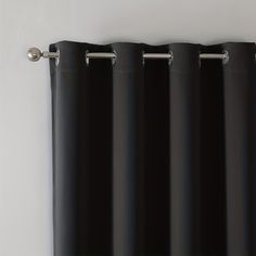 black curtains hanging on the side of a white wall