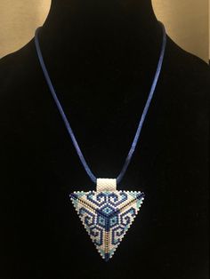 a beaded necklace is displayed on a mannequin neckline with a blue cord