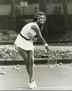 a black and white photo of a woman playing tennis