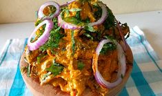 a wooden bowl filled with food on top of a blue and white checkered table cloth